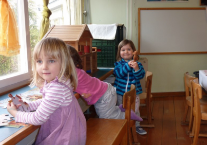 Drei kleine Mädchen mit verschiedenen Dingen beschäftigt